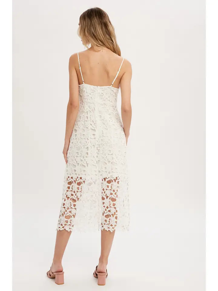 Woman wearing a white lace dress on a plain background
