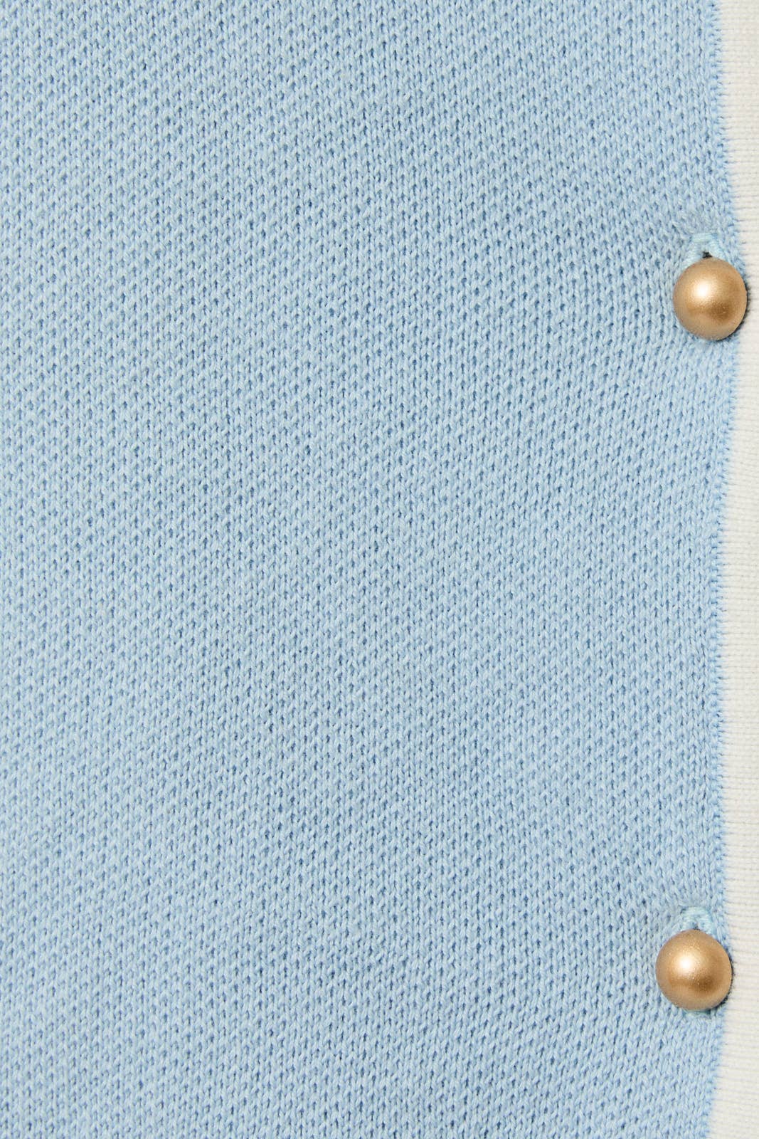 Light blue fabric with gold buttons on a textured background