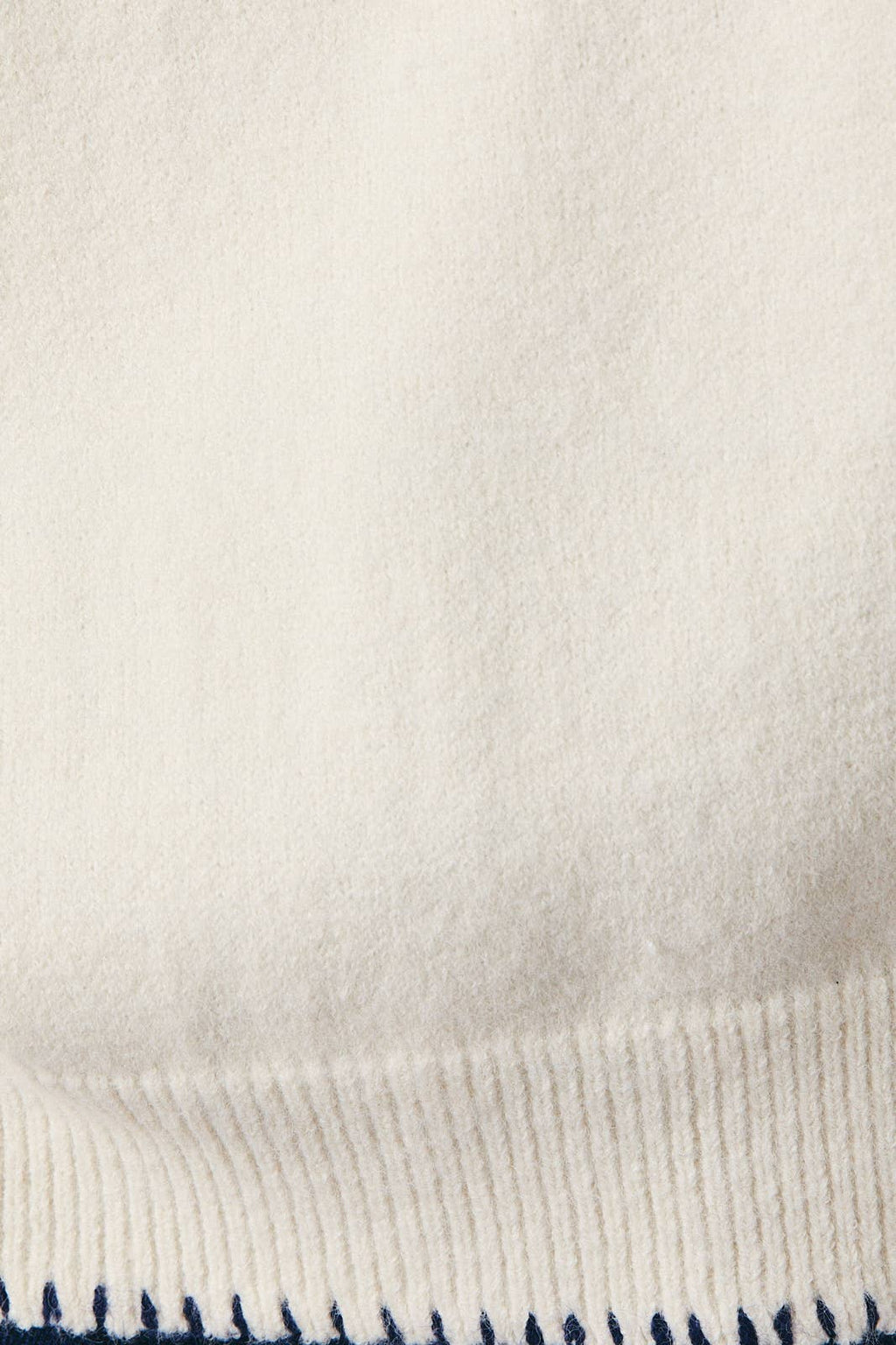 Close-up of a textured fabric with a subtle pattern on a light background