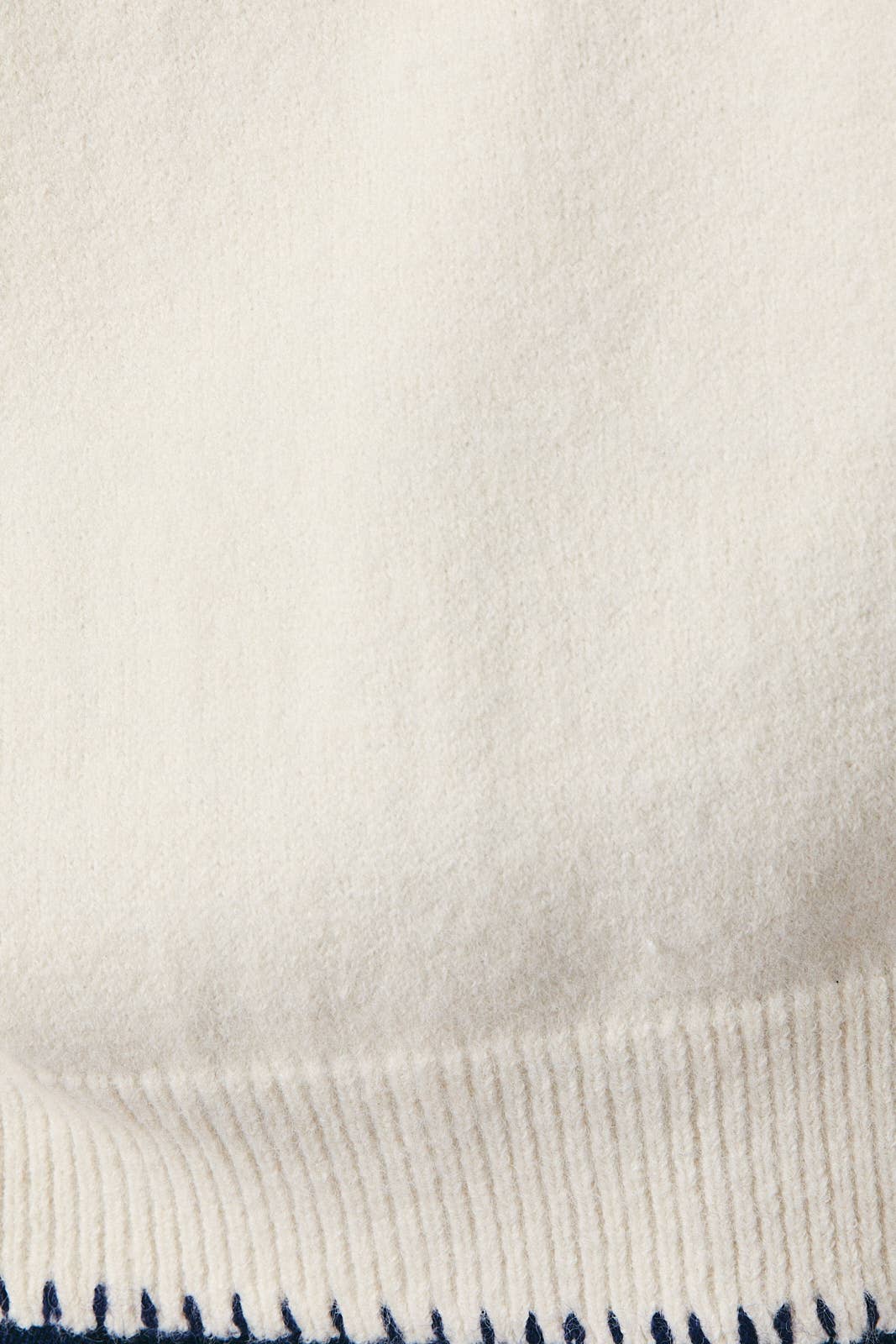 Close-up of a textured fabric with a subtle pattern on a light background