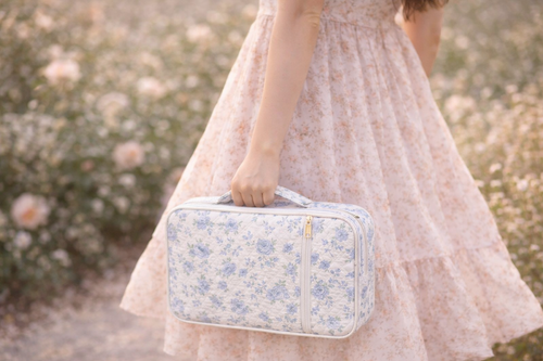 Person holding a floral-patterned bible case in a garden setting